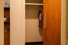 Commons Hall sliding door closet, with maroon Texas A&M T-shirt hanging up inside