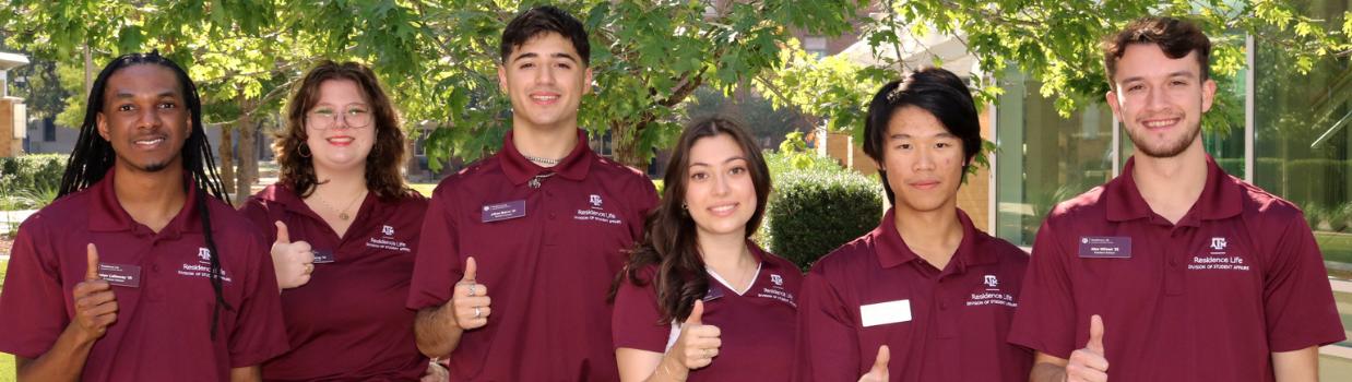 Resident advisors smiling with gigem sign