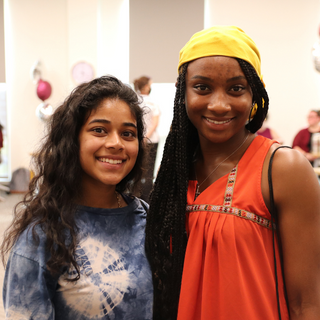 two students standing together smiling